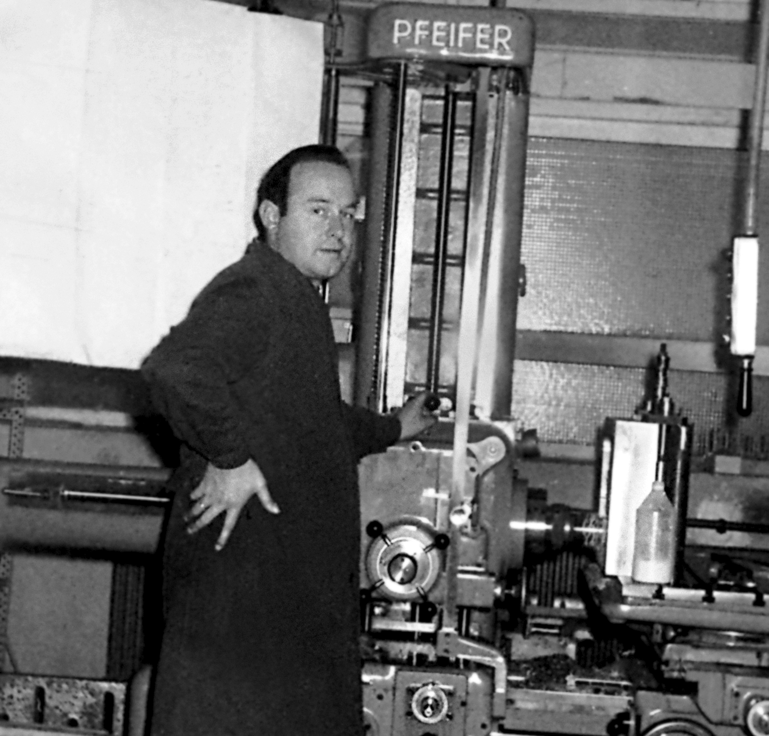 Man operating machinery in an industrial setting, black and white photo.
