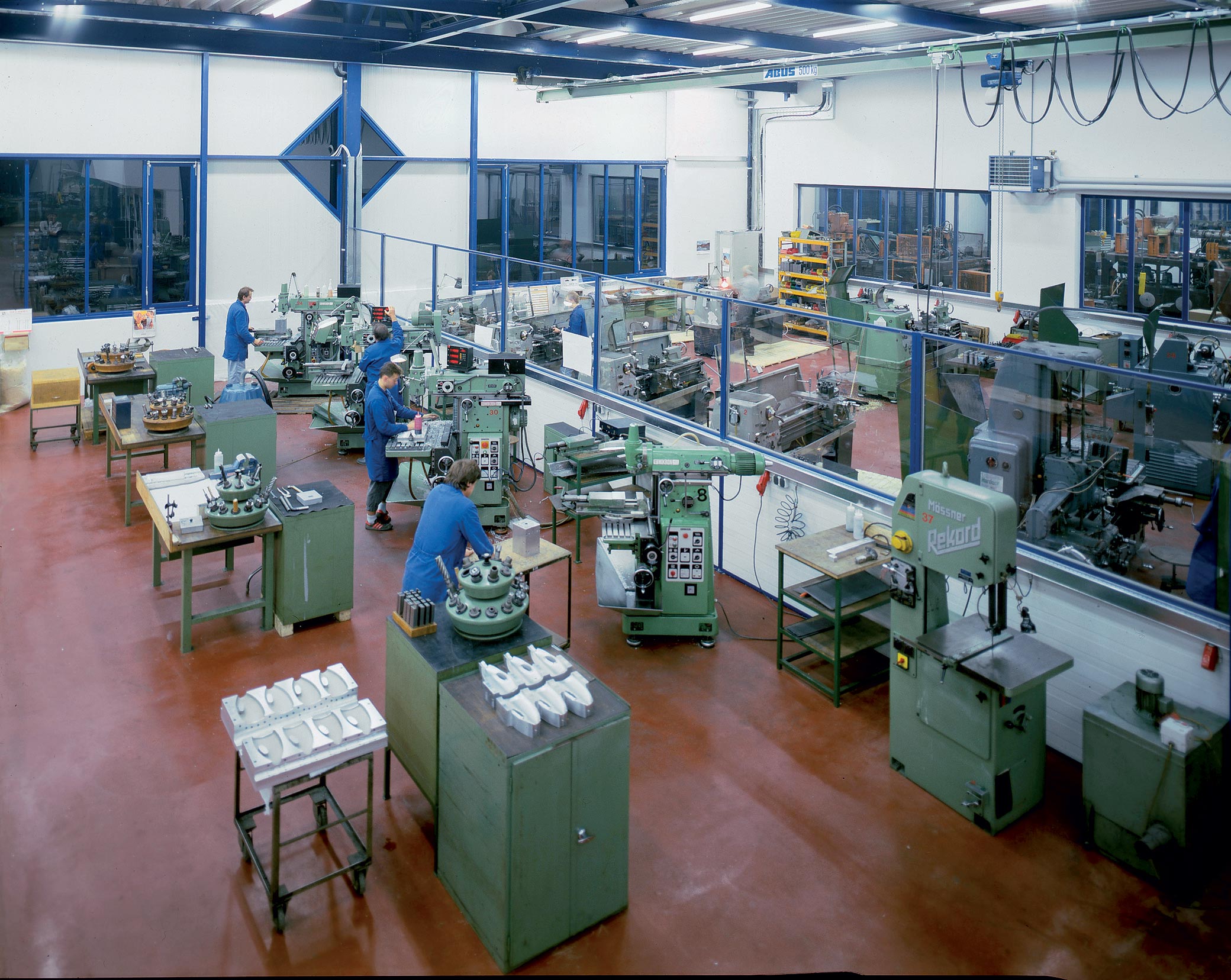 Manufacturing facility with machines and workers assembling products.