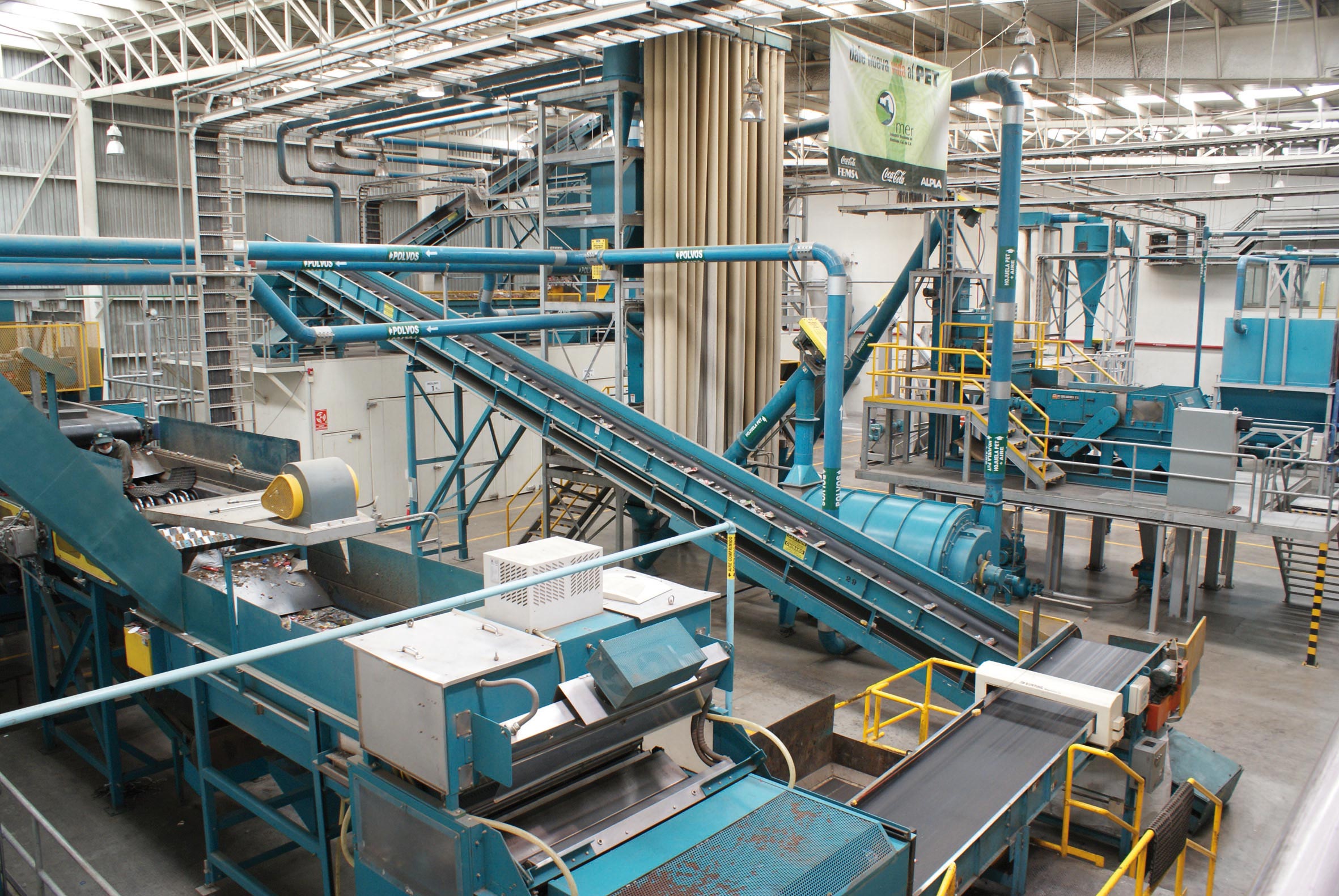Factory floor with blue conveyor systems and machinery.