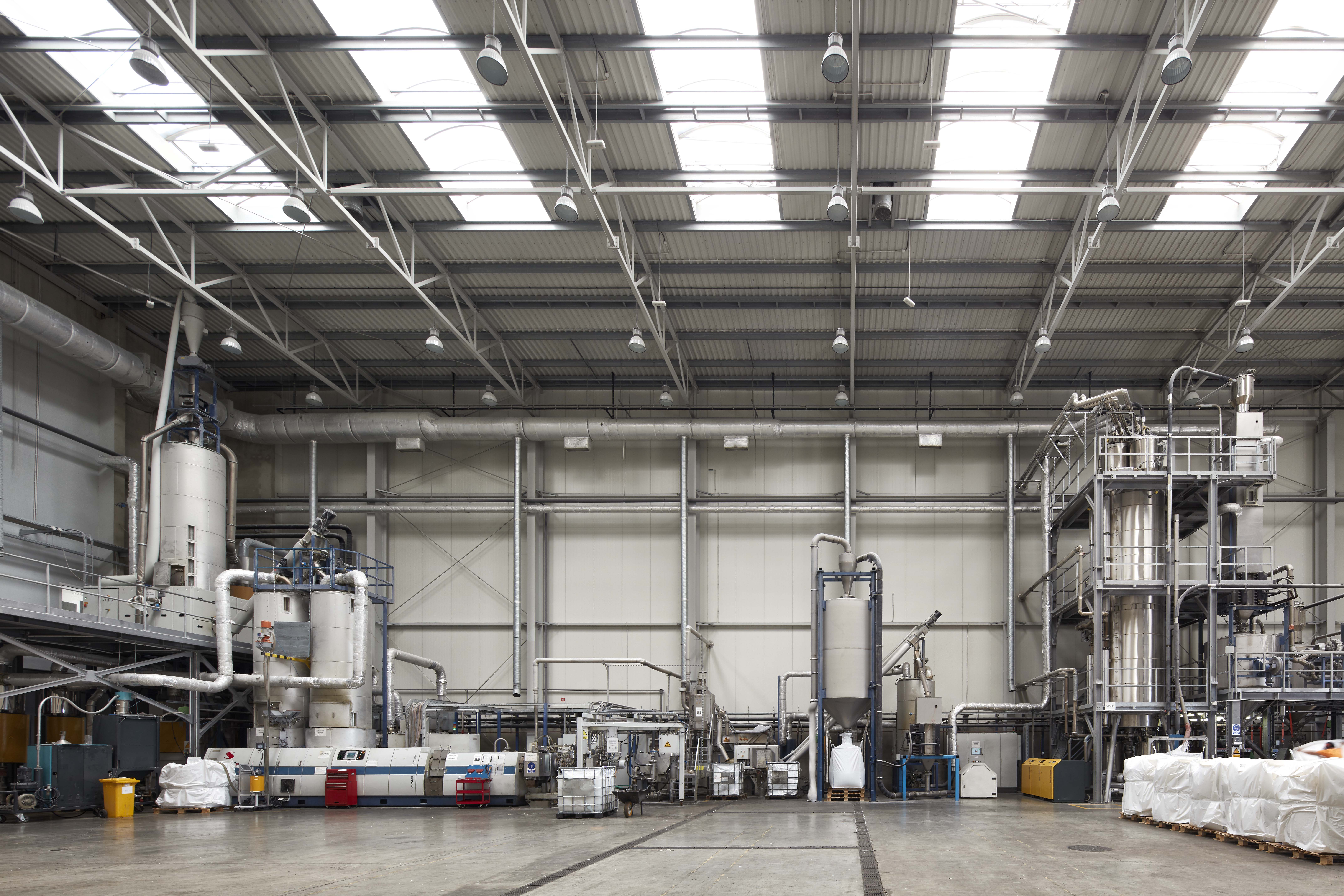 Modern industrial facility interior with large machinery and high ceilings.