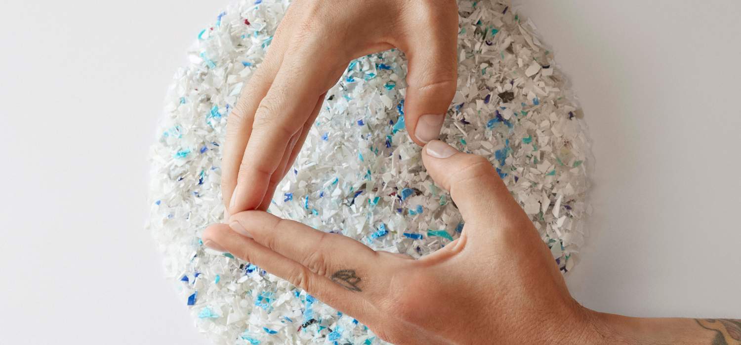 Hands shaping a circle above a textured, multicolored surface on a white background.