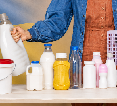 Woman presenting various plastic packaging containers in front of the Ukrainian flag, representing ALPLA's packaging solutions for the Ukraine region.