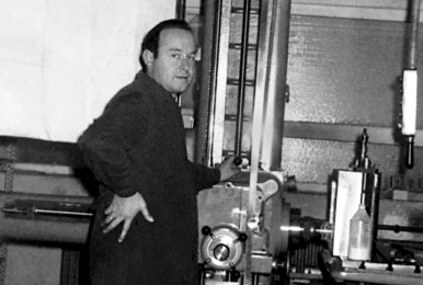 Man operating machinery in an industrial setting, black and white photo.