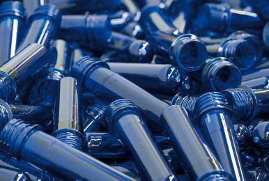 Blue plastic preforms scattered in a pile.