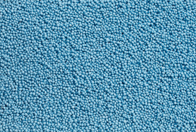 Blue plastic pellets clustered together.