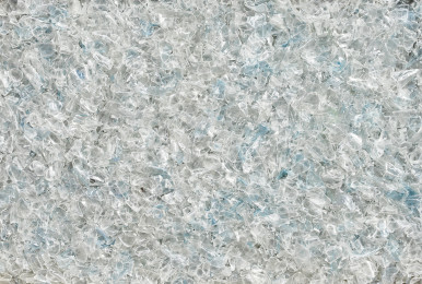 Shredded plastic ready for recycling, mix of clear and light blue pieces.