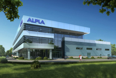 Modern ALPLA building under clear blue sky, lush green surroundings.