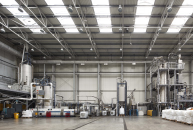 Modern industrial facility interior with large machinery and high ceilings.