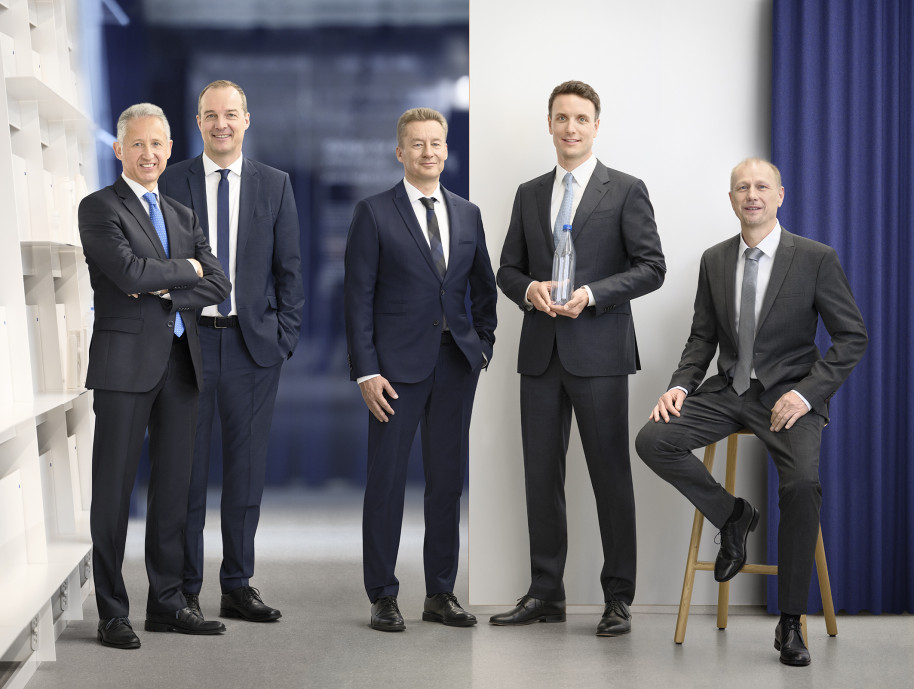 Des cadres en costume souriant dans un bureau.