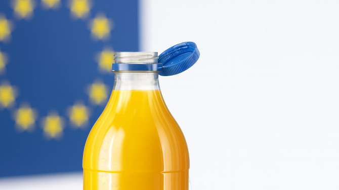Orangensaftflasche mit blauem Verschluss vor einem Hintergrund mit EU-Flagge.