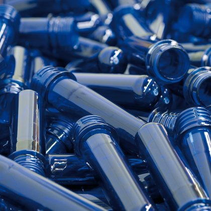 Blue plastic preforms scattered in a pile.
