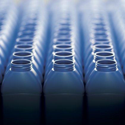 Rows of blue plastic bottles in a manufacturing setting.