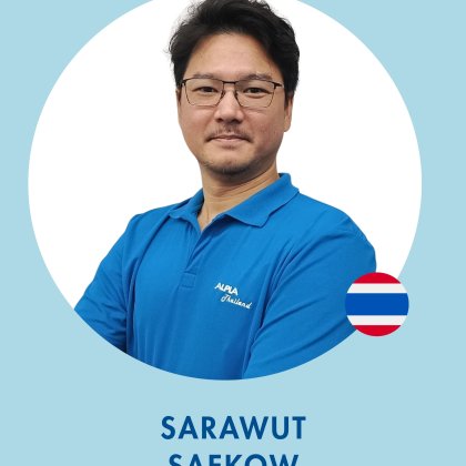 Business Development Manager at ALPLA Man in blue polo shirt with crossed arms, blue background, flag badge on right.