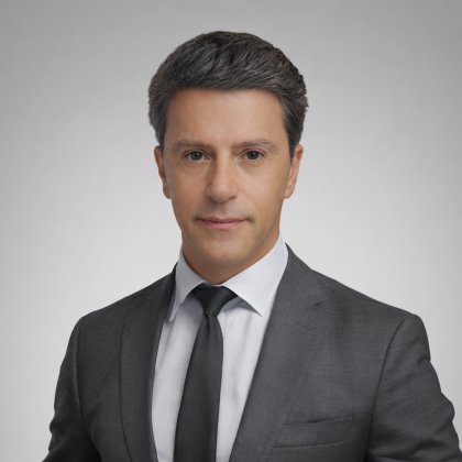 Nelson Abreu, Country Manager of Angola, in a gray suit and black tie on a neutral background.