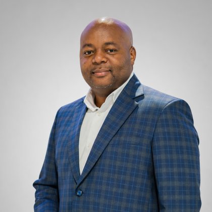 Sibusiso Yende, General Manager of ALPLA Southern Africa, smiling against a gray background.